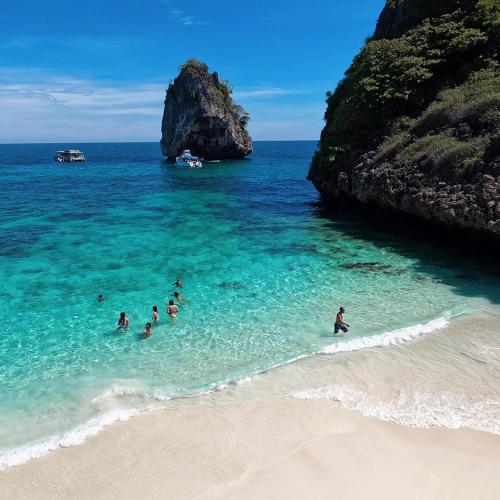 a group of people in the water at a beach at Pimalai Resort & Spa in Ko Lanta