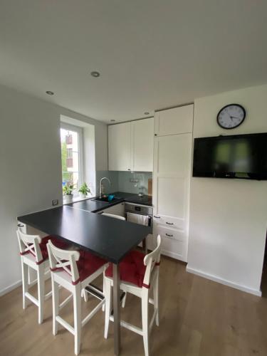 una cocina con mesa y sillas y un reloj en la pared en Apartmán Na Manhattanu, en Rokytnice nad Jizerou