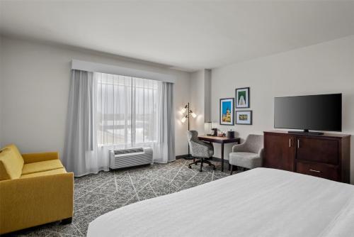 a hotel room with a bed and a flat screen tv at Hampton Inn and Suites Trophy Club - Fort Worth North in Trophy Club