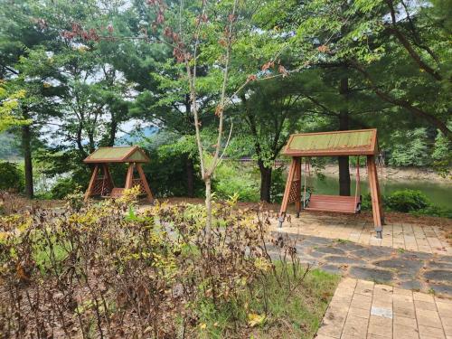 a park with a bench and a gazebo at Goesan Joryeong Pension in Sangch'o