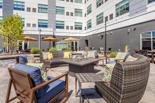 a patio with chairs and tables and a building at Cambria Hotel Davenport Quad Cities in Bettendorf
