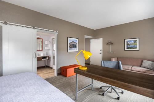 a room with a bed and a desk and a couch at Hampton Inn And Suites Logan, Ut in Logan