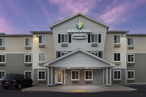 a building with a sign on top of it at WoodSpring Suites Spartanburg - Duncan in Duncan