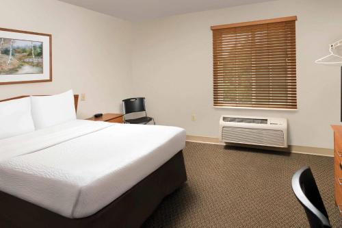 a hotel room with a bed and a window at WoodSpring Suites Spartanburg - Duncan in Duncan