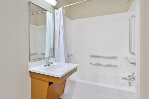 a white bathroom with a sink and a shower at WoodSpring Suites Spartanburg - Duncan in Duncan