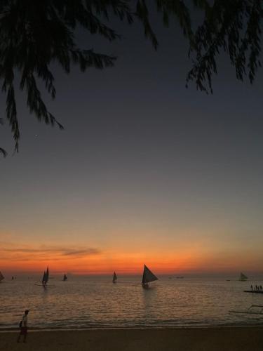 a group of boats in the ocean at sunset at Gracias Inn Boracay in Boracay