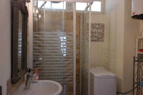 uma casa de banho com um chuveiro, um lavatório e um WC. em Penthouse Apartment overlooking Place Carnot em Carcassonne