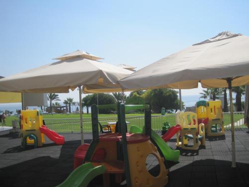 a playground with play equipment under an umbrella at Polyxenia Isaak Luxury Villas and Apartments in Protaras