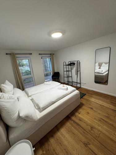 a bedroom with a large white bed and a mirror at Prestige Apartments - Urban Lofts Reutlingen in Reutlingen