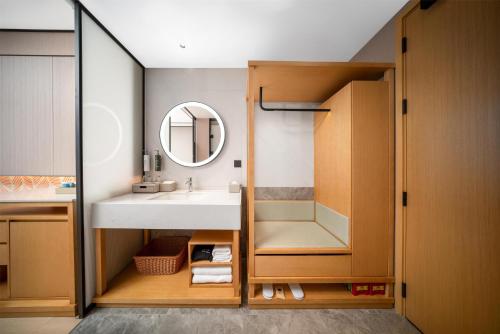 a bathroom with a sink and a mirror at Hilton Garden Inn Taizhou Xinghua in Xinghua