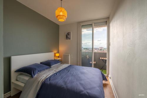 une chambre avec un lit et une grande fenêtre dans l'établissement Toulouse Appartment 3 bedrooms balcony panoramic view - 10 min Train station & Metro, à Toulouse
