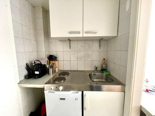 a small kitchen with a sink and white cabinets at 3 minutes walking from Lausanne Train station in Lausanne