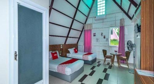 a bedroom with two beds and a table and chairs at Dreamland Beach Holiday in Kudat