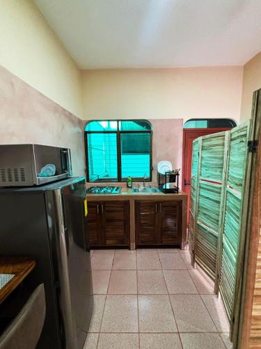 a kitchen with a sink and a refrigerator at Departamento Fila in Puerto Escondido