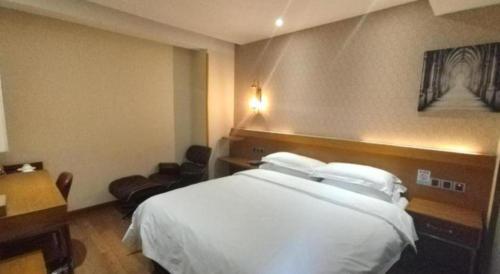 a hotel room with a white bed and a desk at James Joyce Coffetel Xian Big Goose Pagoda Tang Paradise Branch in Xi'an