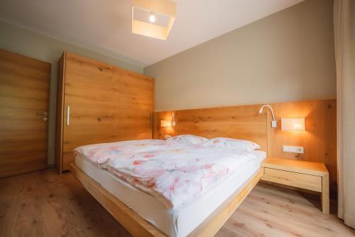 a bedroom with a large bed with a wooden headboard at Apartment Egghof im Weingut in Merano