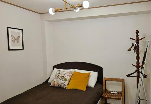 a bedroom with a bed with a yellow pillow on it at Dada House in Seoul