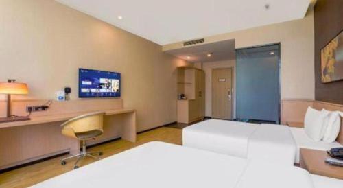 a hotel room with a large bed and a desk at IU Hotel Taiyuan Changfeng West Street The Mixc in Taiyuan