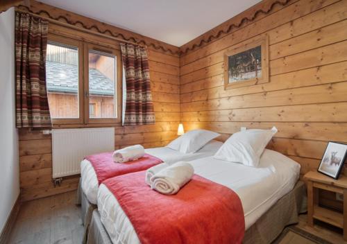 - une chambre avec 2 lits dans une pièce dotée de murs en bois dans l'établissement Appartement Ecrin 214, à Tignes