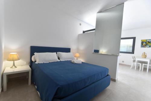 a bedroom with a blue bed and a table at FA Appartamenti Rurali in Galatone
