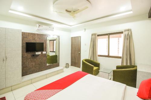 a bedroom with a bed and a flat screen tv at Hotel O Eagle Fantasy in Vānivilāsa Puram