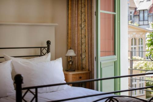 a bedroom with a bed and a window and a lamp at Villa Sedan - Destigo Hotels in Sopot