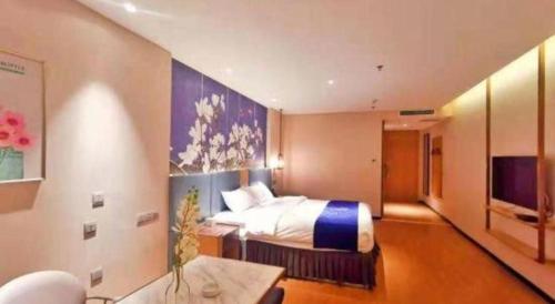 a large bedroom with a bed and a tv at Magnotel Shenyang Consulate Qingnian Street in Shenyang