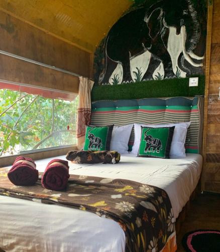 a bedroom with a bed with a painting on the wall at Elephant Lake Villa, Yoga & Meditation Sanctuary in Sigiriya