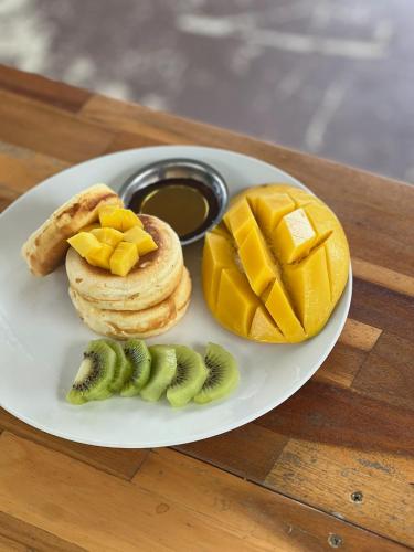 a plate with a sandwich and fruit on a table at The Canopy Krabi in Ao Nang Beach
