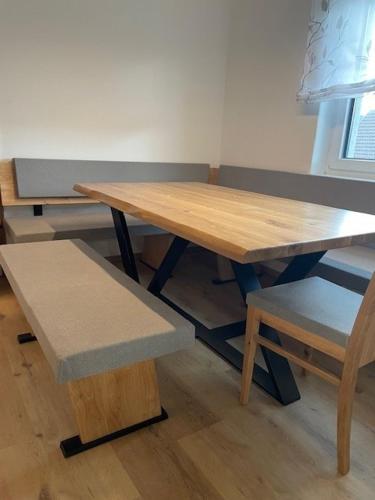 a wooden table and a bench and a wooden table and chair at Ferienhaus Meisterl in Sankt Marein bei Neumarkt