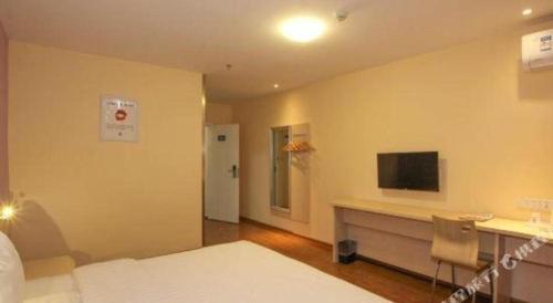 a bedroom with a bed and a desk and a television at 7 Days Inn Guilin Beiji Plaza Yushan Garden in Guilin