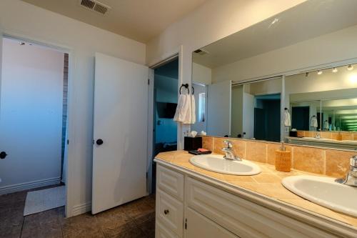 a bathroom with two sinks and a large mirror at Spacious Lux Estate l 8 mins to Strip in Las Vegas