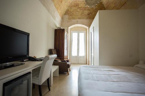 a bedroom with a bed and a desk with a television at Hotel Casino Ridola in Matera