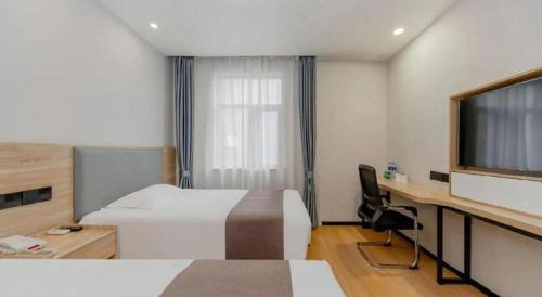 a hotel room with a bed and a desk and a tv at GreenTree Inn Nanjing Confucius Temple Sanshan Street Subway Station Express Hotel in Nanjing