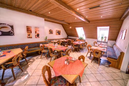 Hotel Huber في موسبورغ: مطعم فيه طاولات وكراسي في الغرفة