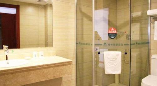 a bathroom with a shower and a sink and a toilet at GreenTree Inn Xian Longshouyuan Subway Station Business Hotel in Xi'an