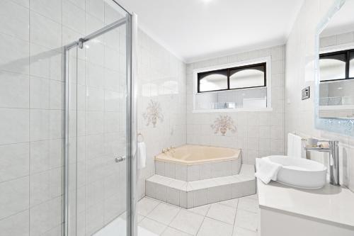 a bathroom with a shower and a tub and a sink at Home Away From Home in Braybrook