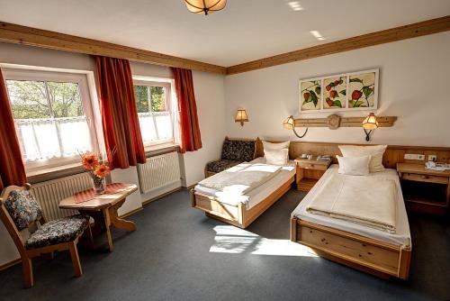 Hotel Huber في موسبورغ: غرفة نوم بسريرين وطاولة وكراسي