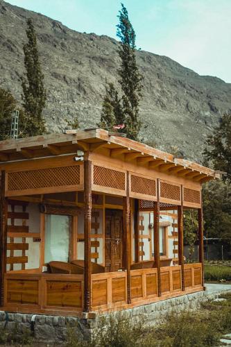 a wooden house with a mountain in the background at Dera Lamsa Resort Shigar in Shigar