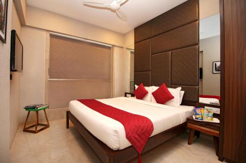 a bedroom with a large bed with red pillows at Theory9 Premium Service Apartments Khar in Mumbai