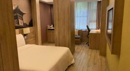 a bedroom with a bed and a desk in a room at Atour Hotel Xi'an High Tech Dazhai Road in Xi'an