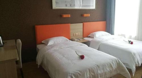 a hotel room with two beds with white sheets at 7 Days Premium Yancheng Dafeng Zhongjiao Meilu City in Yancheng