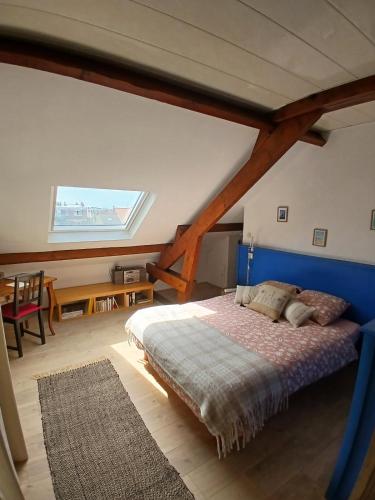 une chambre avec un grand lit dans un grenier dans l'établissement Appt Av de la Mer, à Dunkerque