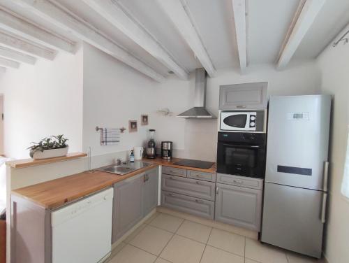 une cuisine avec un réfrigérateur blanc et un évier dans l'établissement Mazet à 5 minutes d'Uzès, à Montaren-et-Saint-Médiers