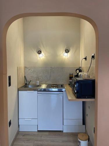 une cuisine avec des armoires blanches et un évier dans l'établissement Studio l'iDOLE, à La Celle-sous-Gouzon