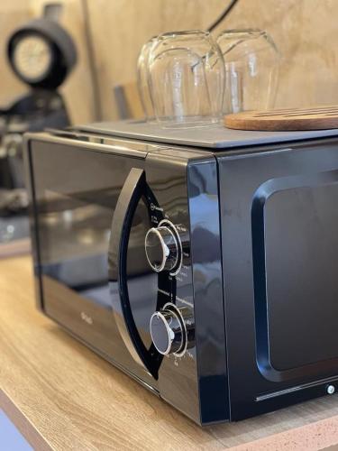 Un four à grille-pain noir est installé au-dessus d'un comptoir. dans l'établissement Studio l'iDOLE, à La Celle-sous-Gouzon