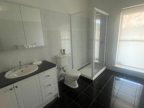a bathroom with a toilet and a shower and a sink at Bella Casa Geelong in Lovely Banks