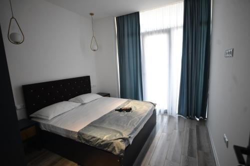 a bedroom with a bed and a large window at Thom Tower in Gonio