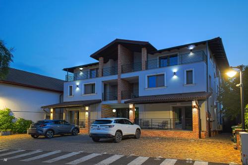 two cars parked in a parking lot in front of a building at First Apartments in Focşani