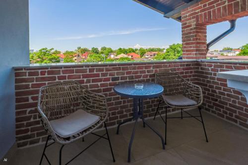 a patio with two chairs and a table on a brick wall at First Apartments in Focşani